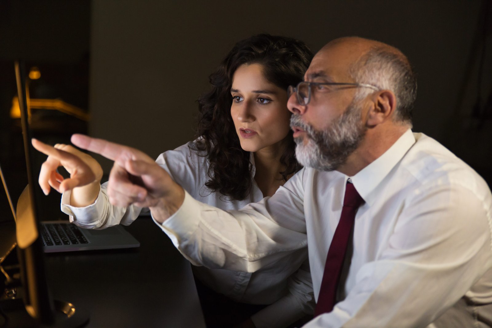 Shocked coworkers pointing at computer monitor